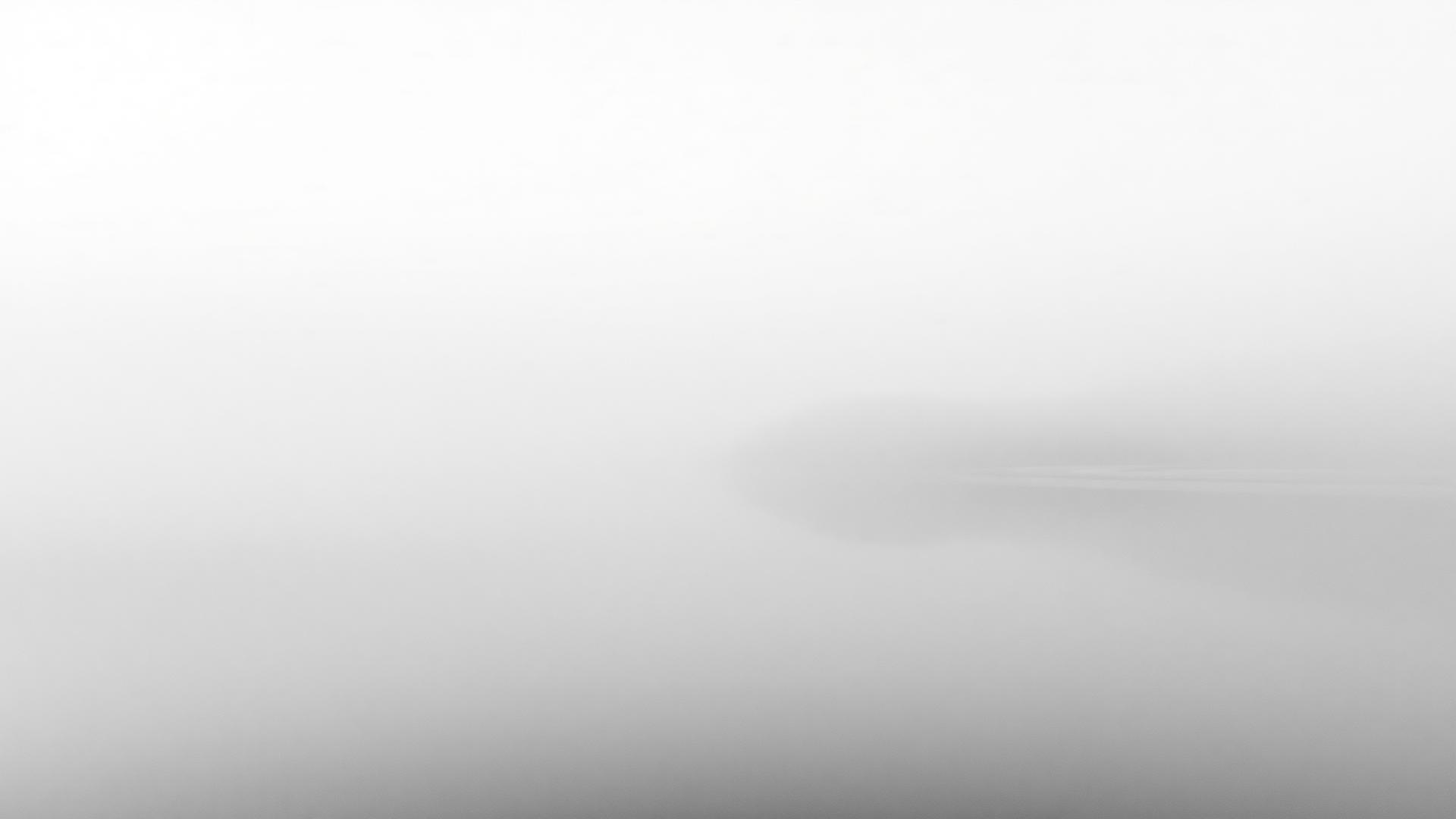 Soft gray mist settling over calm, still water
